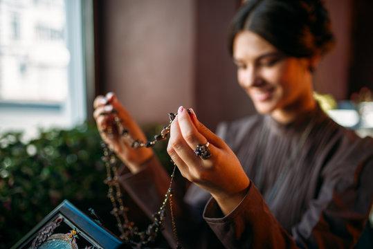 Woman's hands with old fashion style beads
